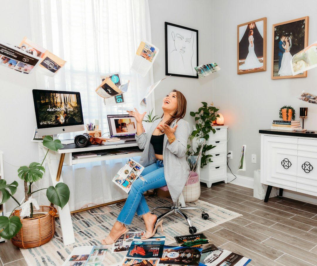 Woman editing photographs on a laptop surrounded by printed photos